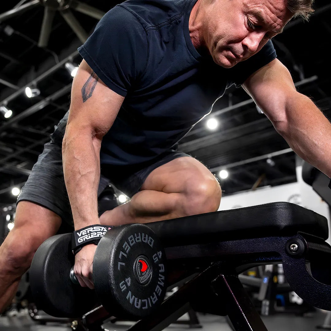 Lifter rowing a loaded dumbbell with Versa Gripps Pro locked to the handle